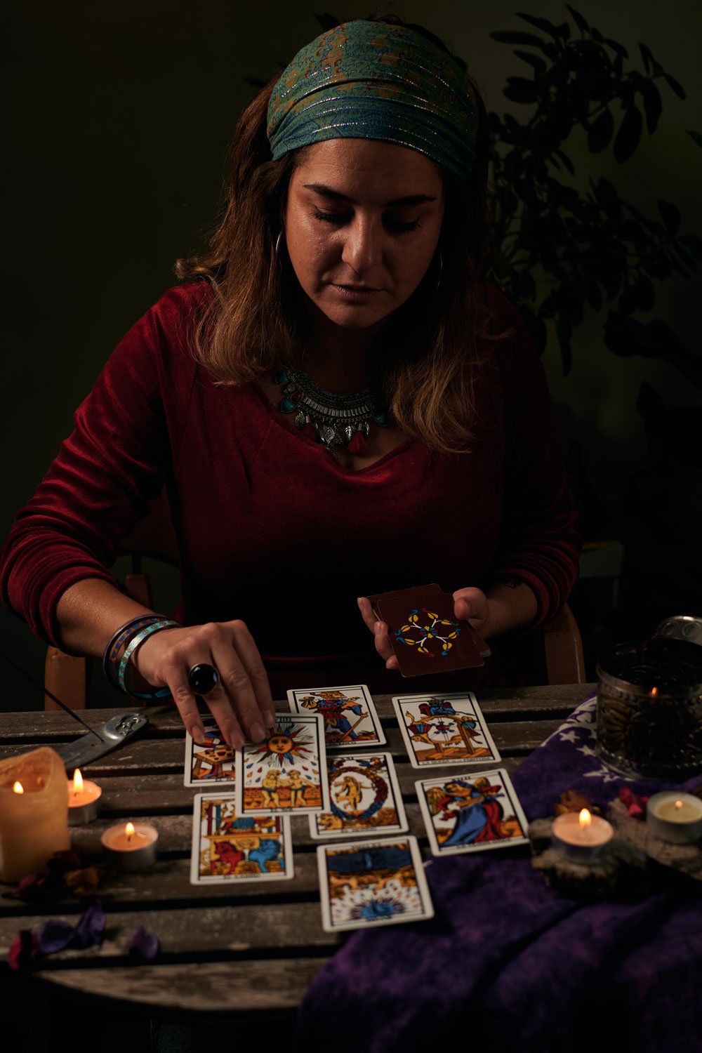 pythoness-reads-tarot-cards-on-a-table-with-candle-2022-03-29-23-44-16-utc.jpg